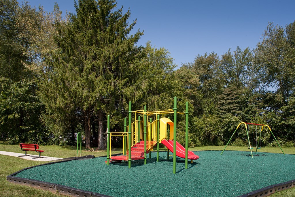 a playground with a red and yellow swing set