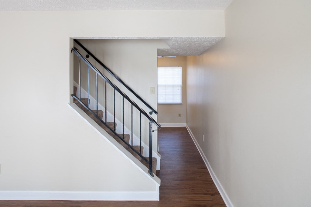 a view of a staircase in a home with white walls and wood floors