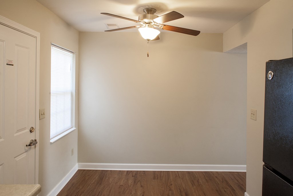 an empty room with a ceiling fan and a door