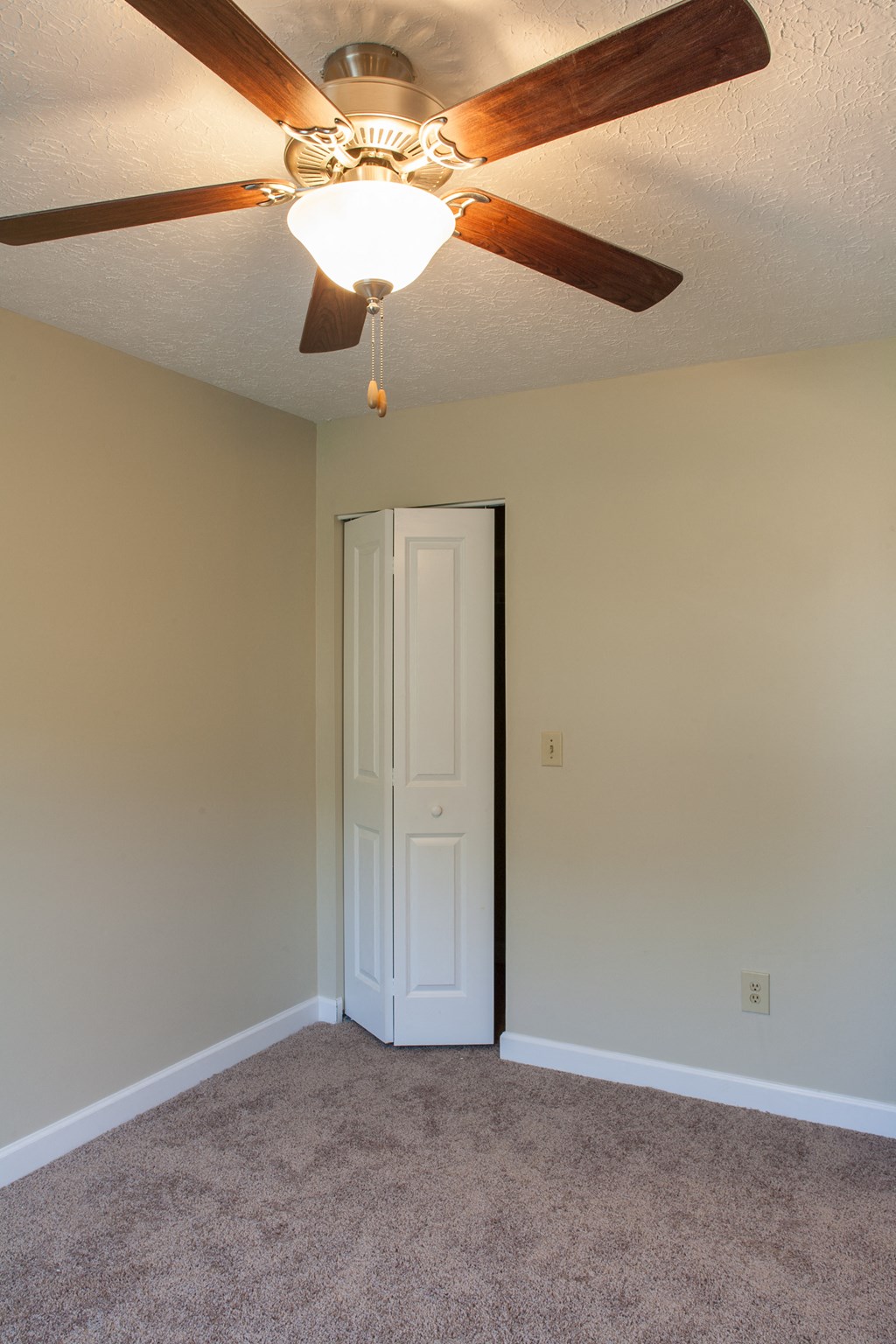 a bedroom with a ceiling fan and a door to a closet