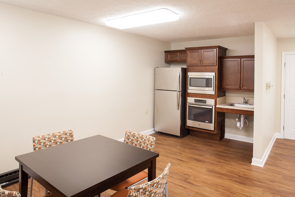 a kitchen and dining room with a table and chairs and a refrigerator