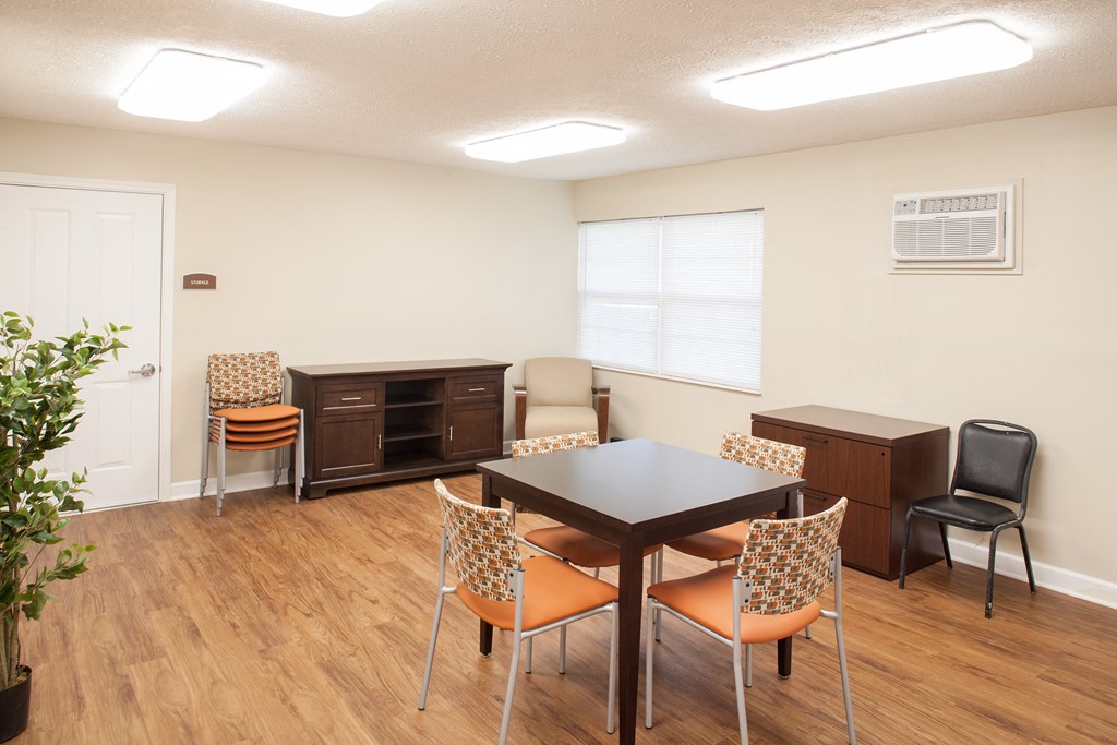 a room with a table and chairs and an air conditioning unit