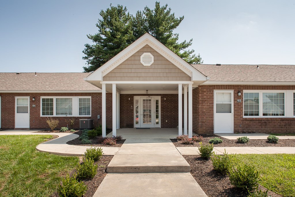 the exterior of a brick building with a walkway in front