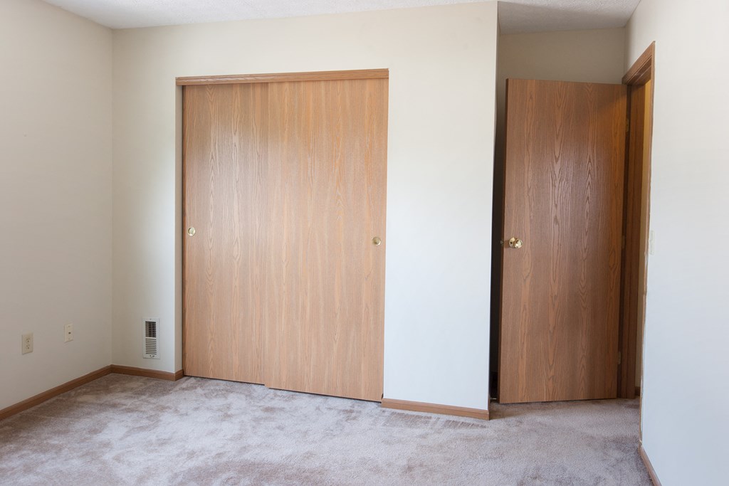 an empty room with two doors and a white wall