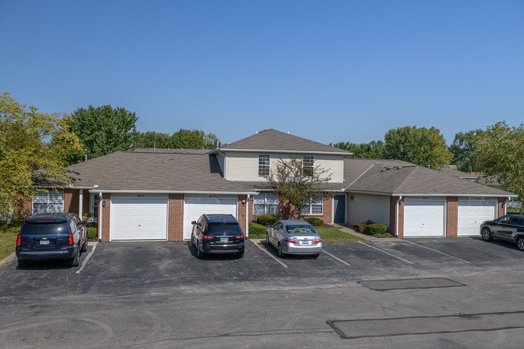 a home with a parking lot with cars in front of it