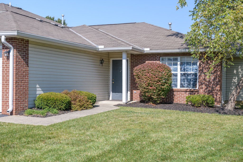 the front of a house with a sidewalk in front of it