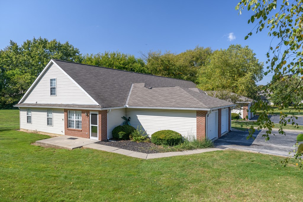 a white house with a gray roof and a driveway