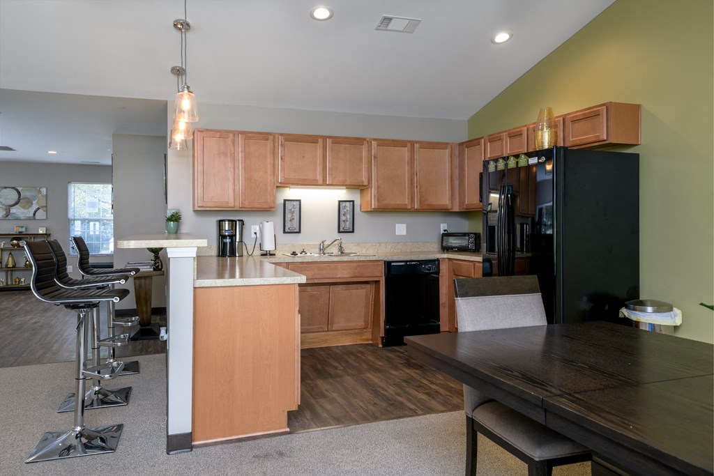 a kitchen and dining room with wooden cabinets and a black refrigerator