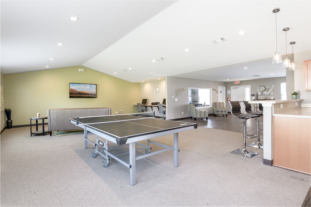 a game room with a ping pong table and a bar