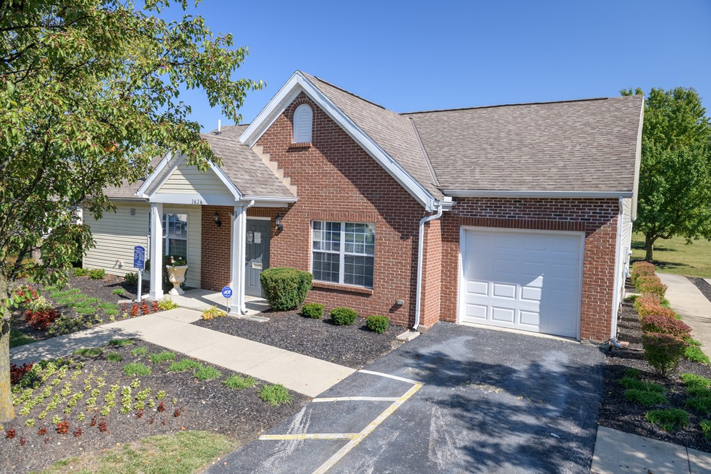 a small brick house with a white garage door