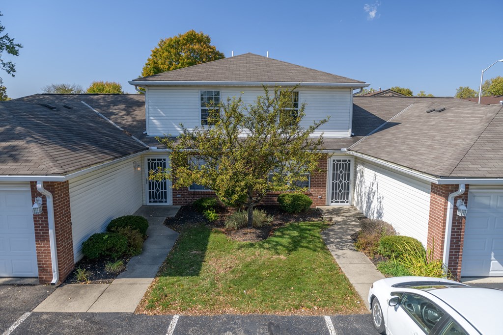 a white house with a tree in the front yard