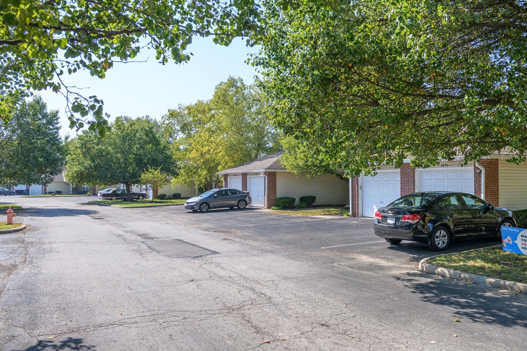 a parking lot with cars parked in front of a house