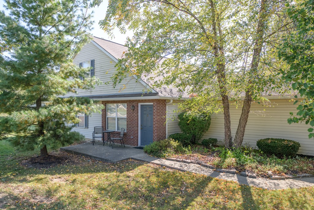the front of the house with a patio and trees