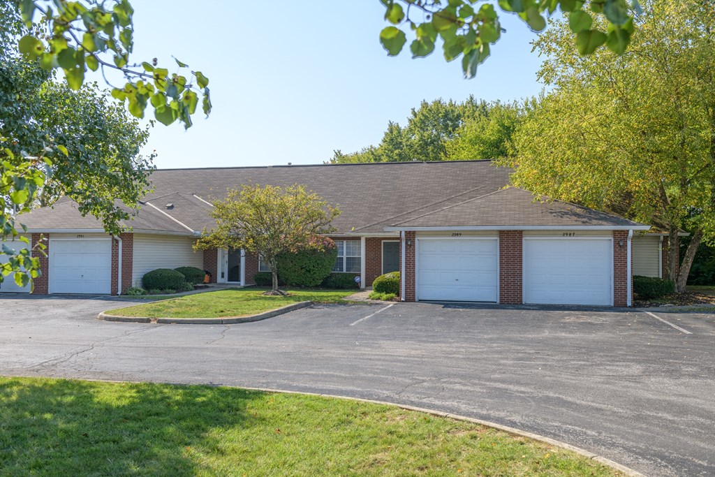 a house with two garages and a driveway in front of it