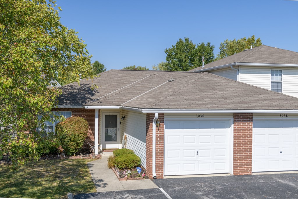 a white house with a gray roof and a white garage door