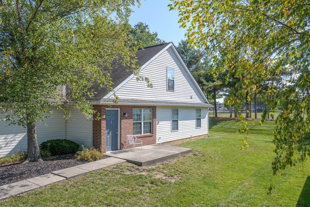 the front of a white house with a blue door