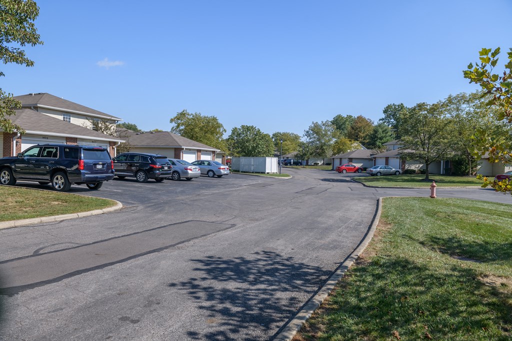 a street in a neighborhood with cars parked in front of houses