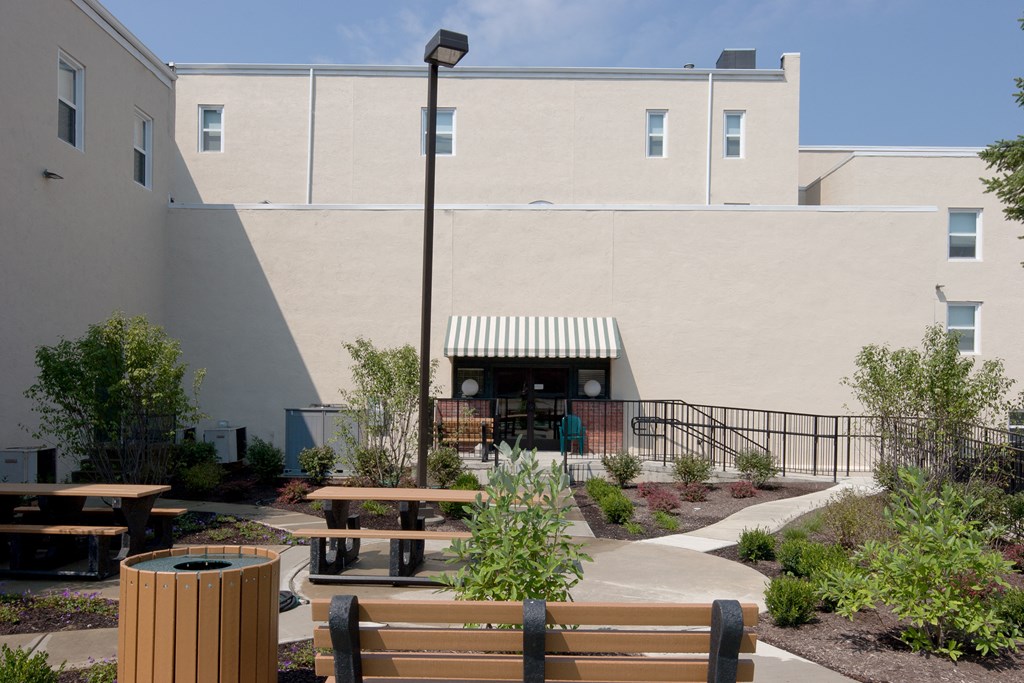 a courtyard with benches and a building in the background