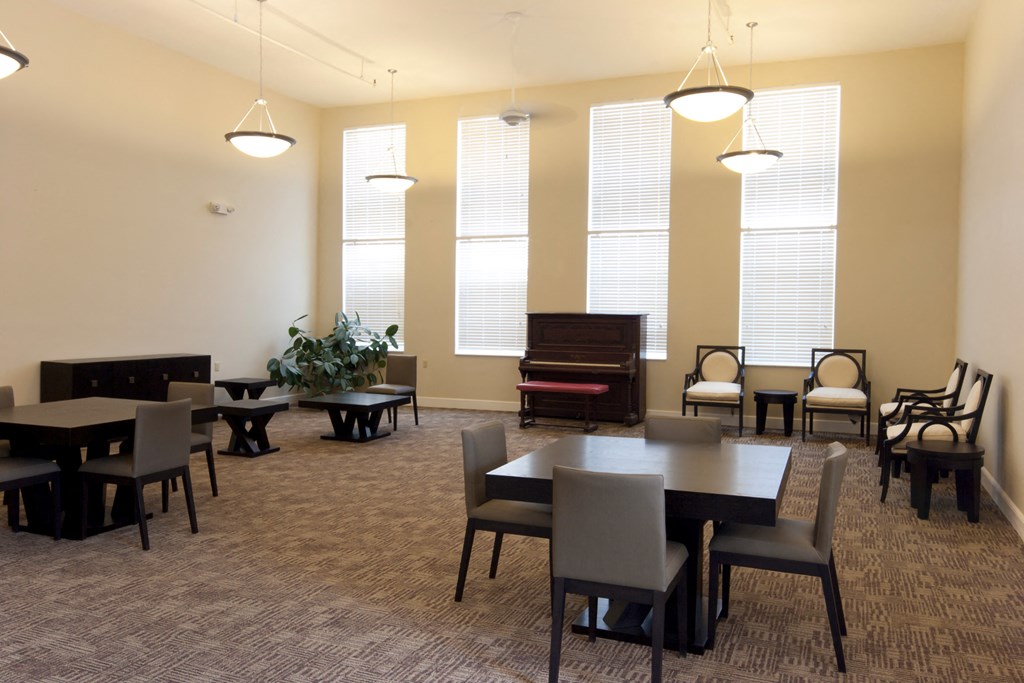 a dining room with tables and chairs and a piano