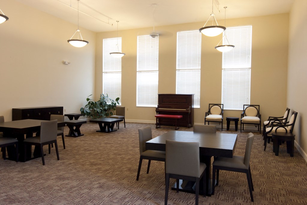 a dining room with tables and chairs and a piano