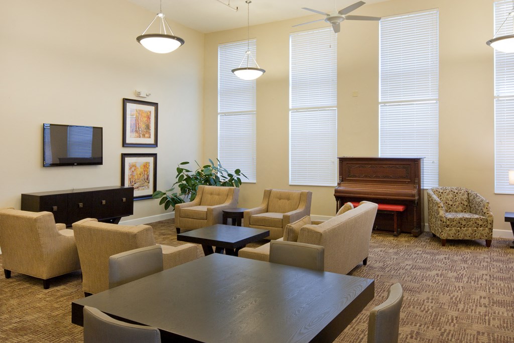 a living room with a table and chairs and a piano