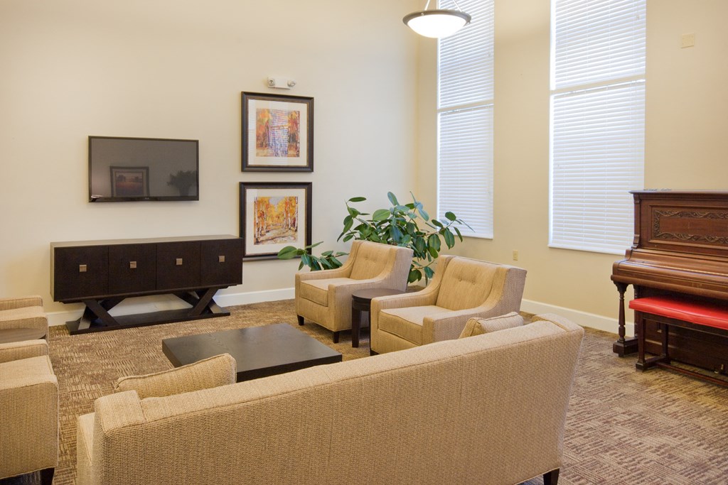 a living room with a couch and chairs and a piano