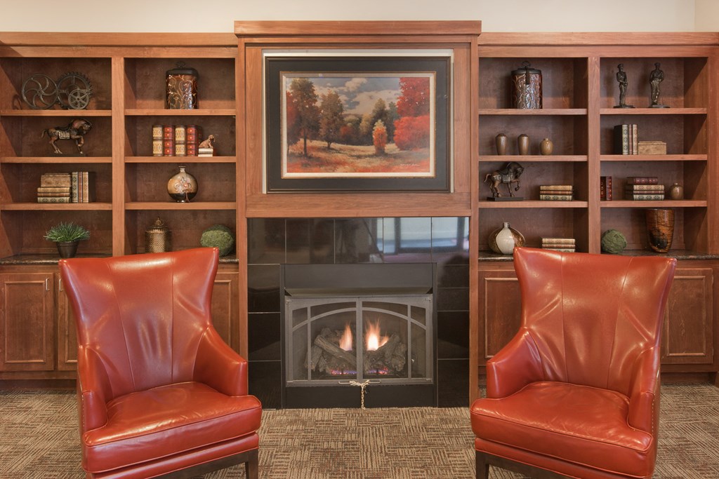 a living room with leather chairs and a fireplace