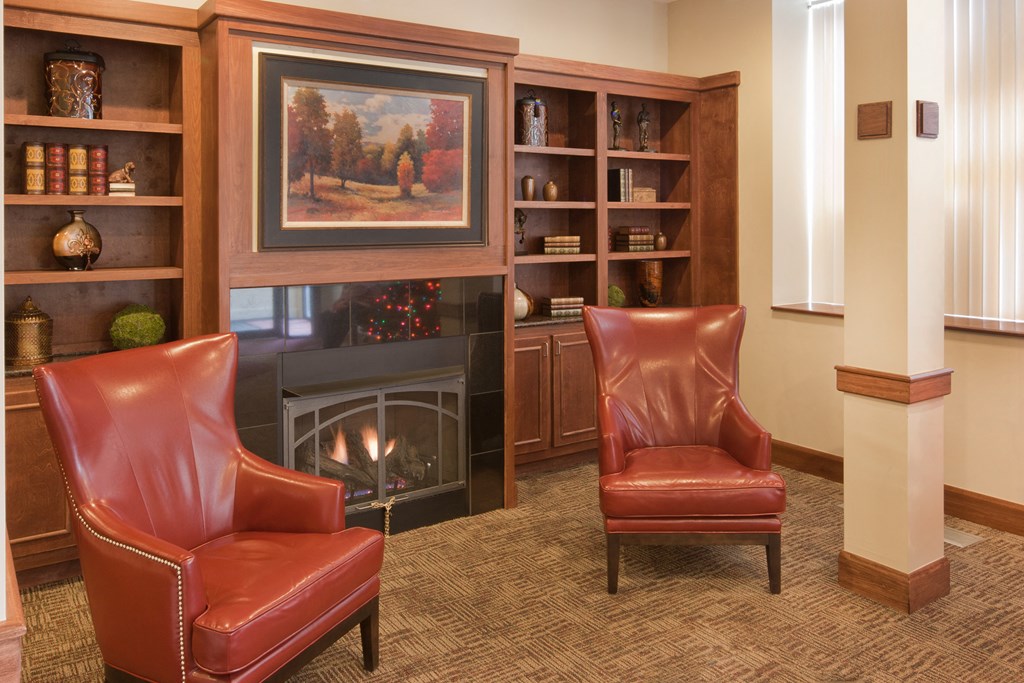 a living room with leather chairs in front of a fireplace
