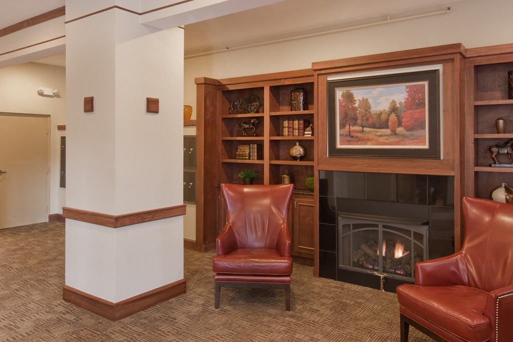 a living room with leather chairs and a fireplace