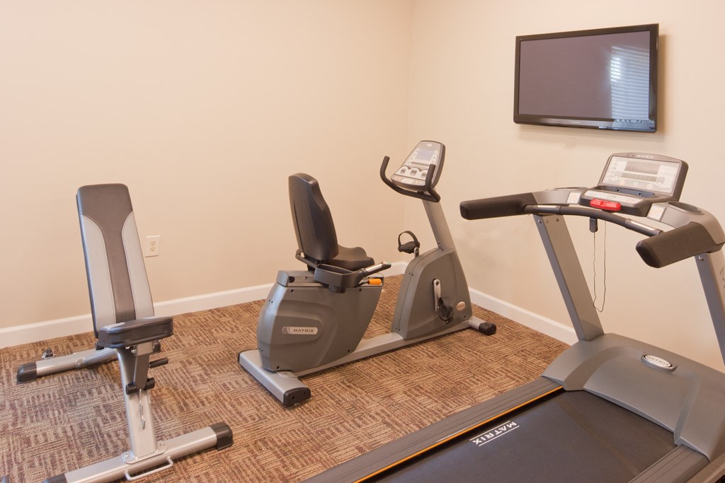 a gym with two exercise bikes and a tv