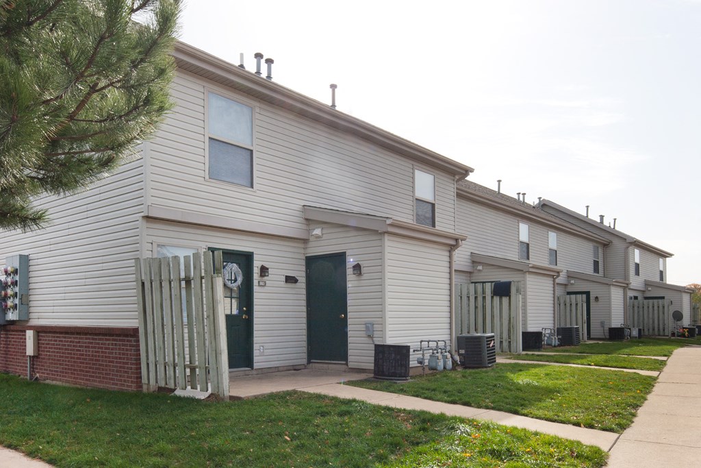 the exterior of a white house with a sidewalk