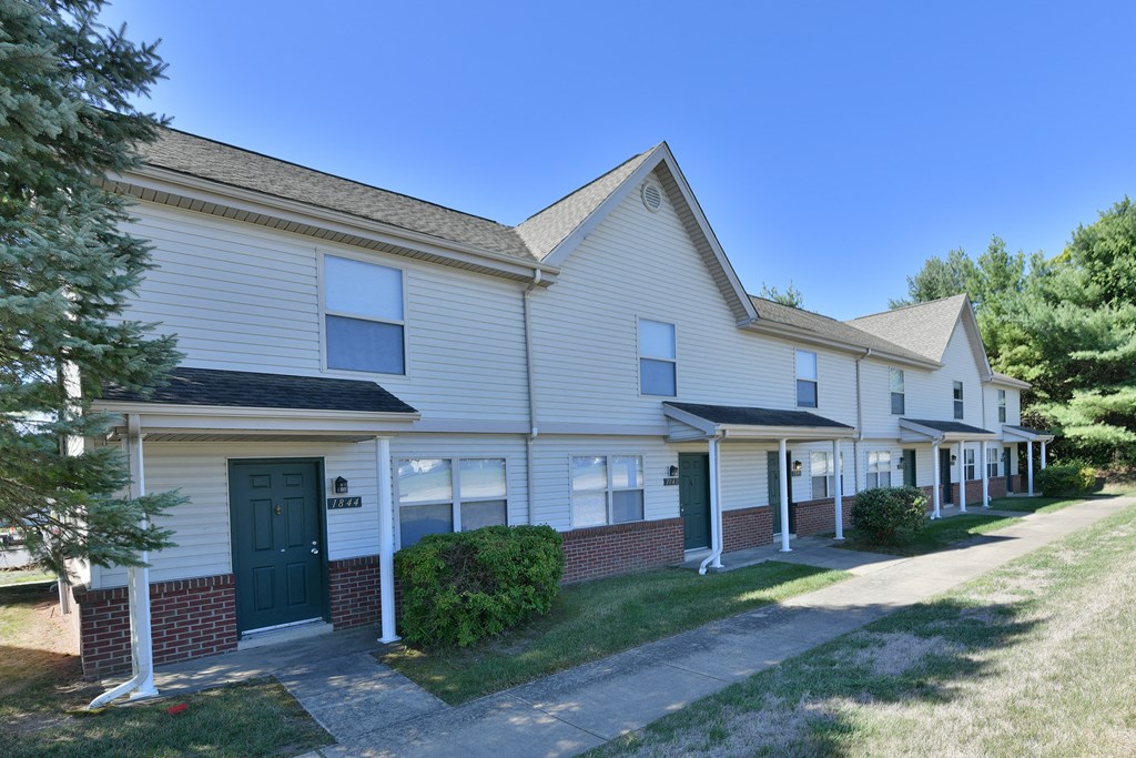 a white house with a green door and a sidewalk