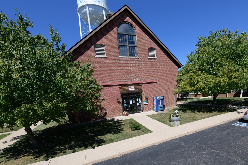 an old brick church with a water tower behind it