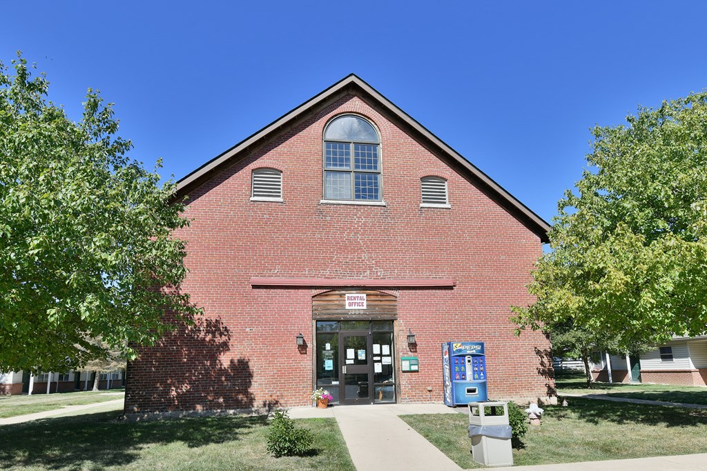 an old brick church with a sidewalk and trees