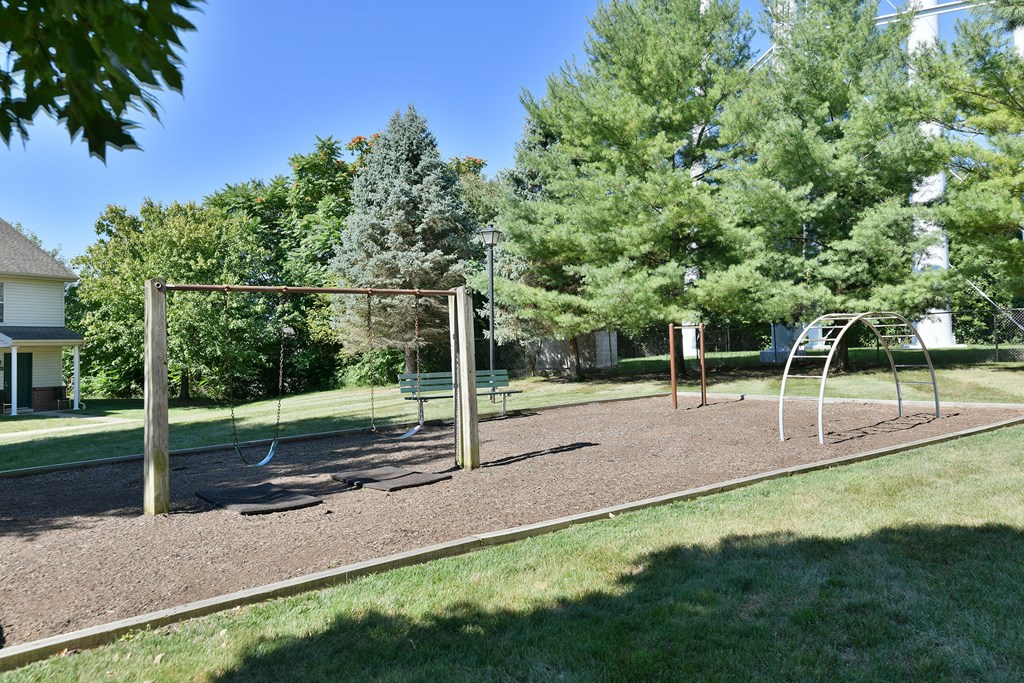 a playground with a swing set in a park