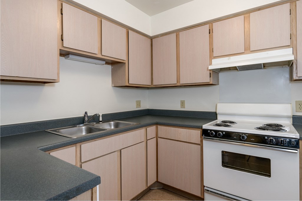 a kitchen with wooden cabinets and a stove and sink