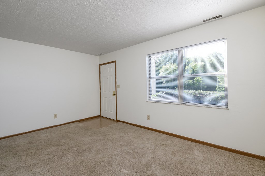 the living room of an apartment with a large window