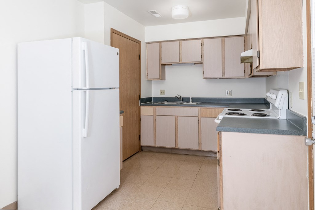 a kitchen with white appliances and wooden cabinets