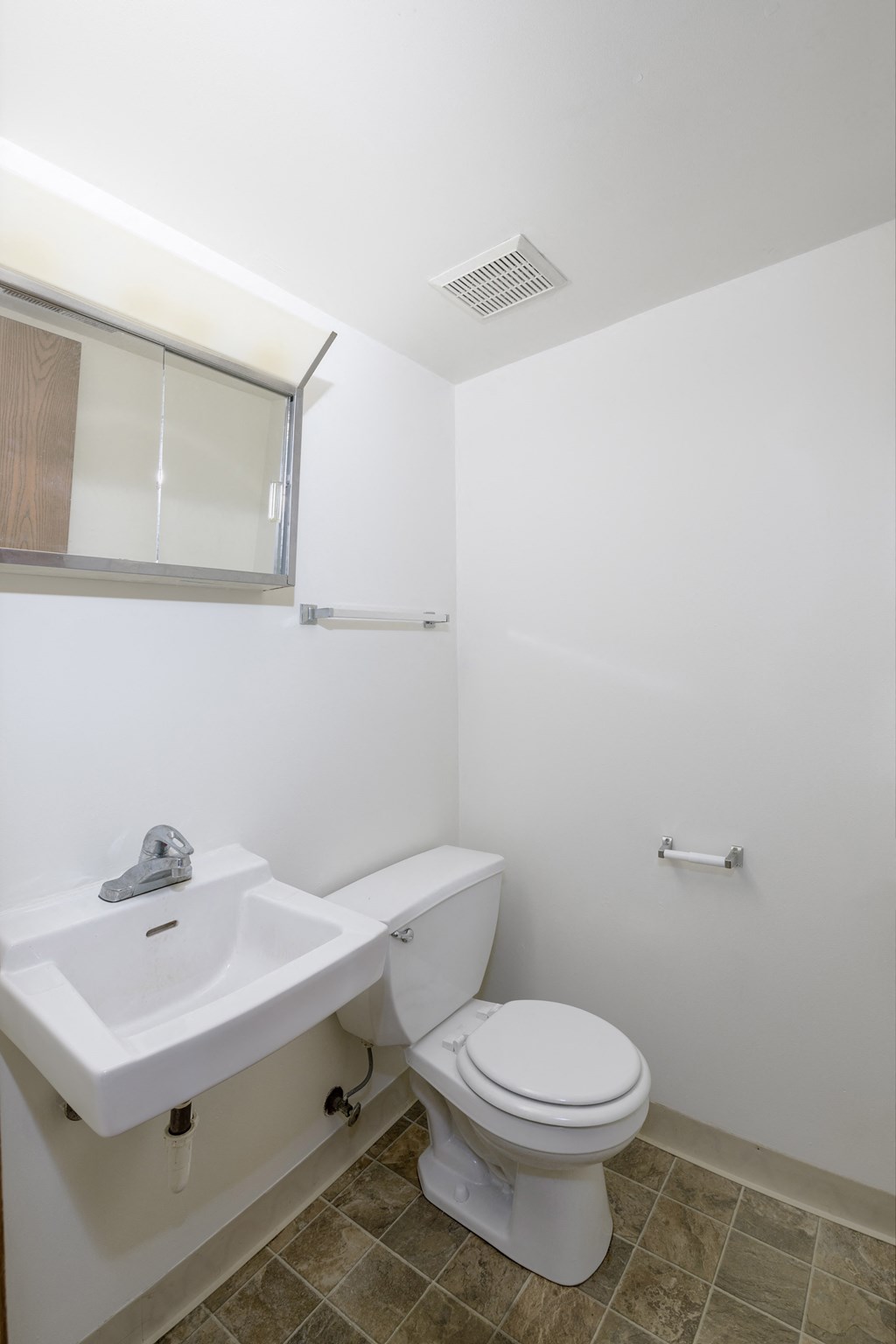 an empty bathroom with a toilet and a sink