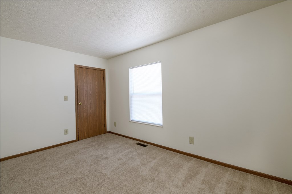 the living room of an empty house with a window and a door