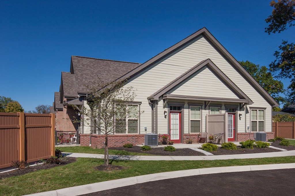 front view of a house with white siding and red doors
