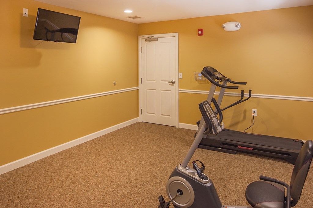 a home gym with an exercise bike and a tv