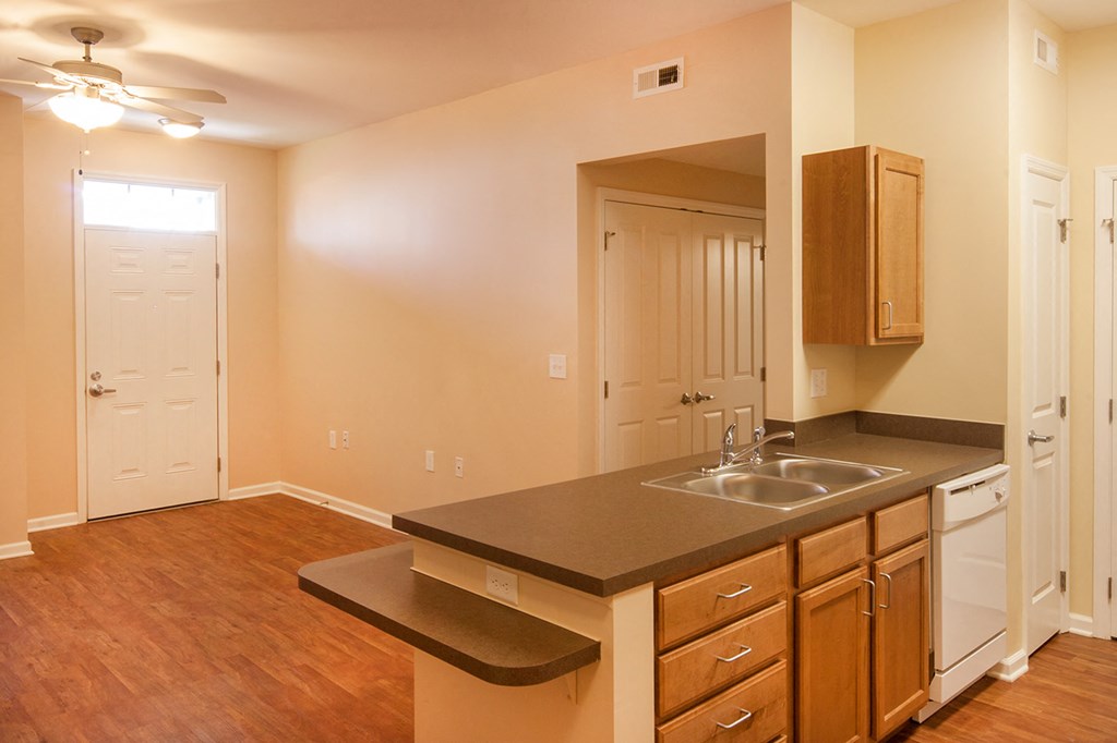 a kitchen with a sink and a mirror in an empty house