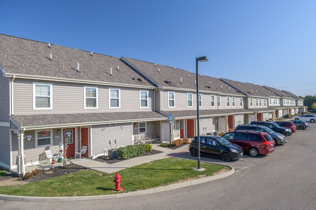 a row of houses with cars parked in front of them