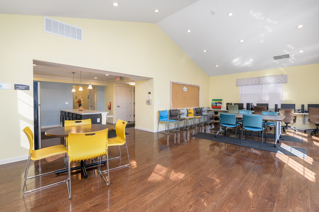 a dining area with tables and chairs and a kitchen with a bar and chairs