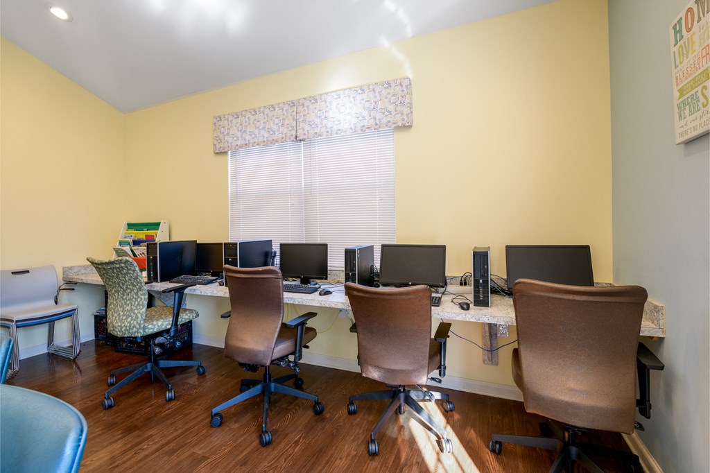 an office with desks with computers and chairs