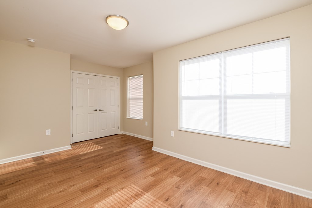 an empty living room with wood floors and a white door