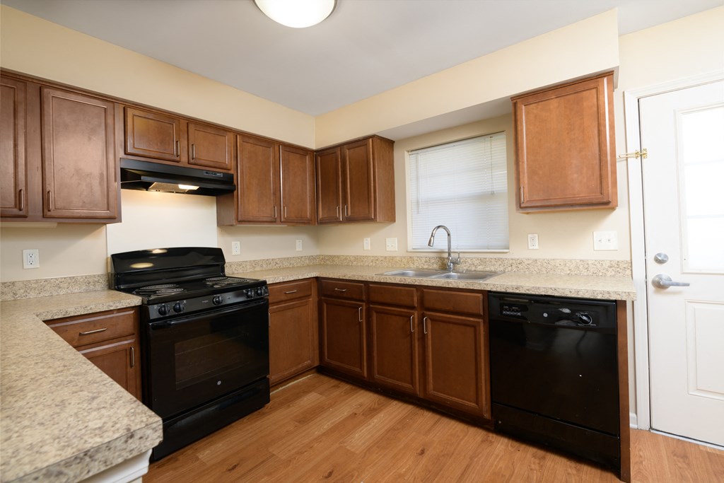 a kitchen with black appliances and wooden cabinets