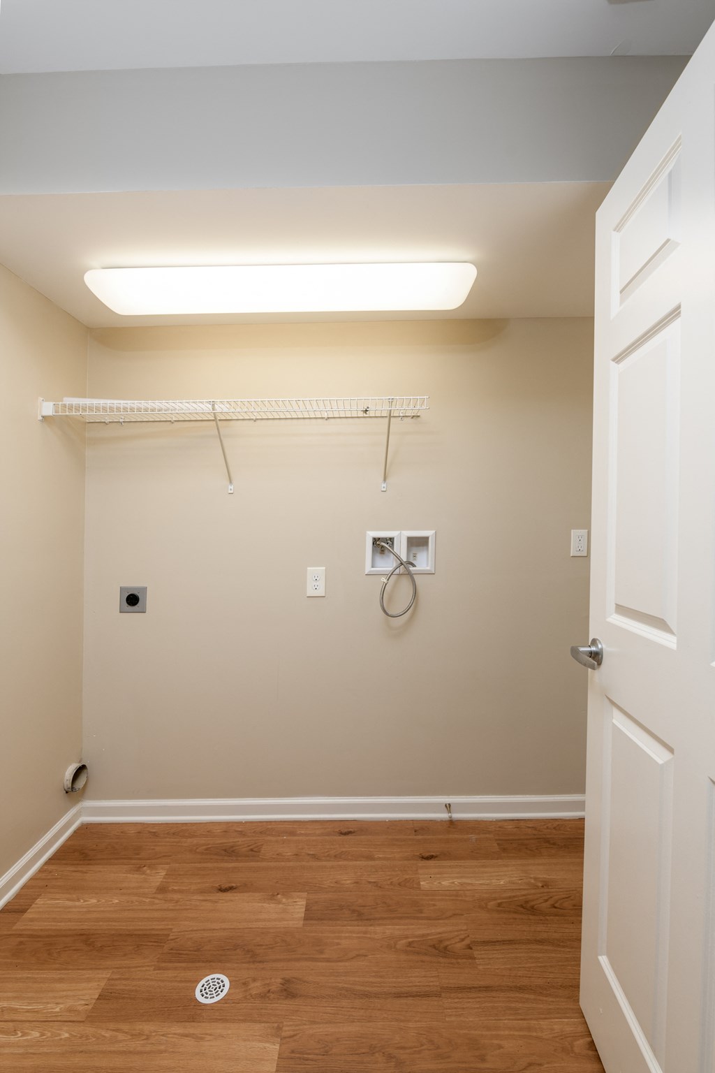 a bathroom with a wooden floor and a white door