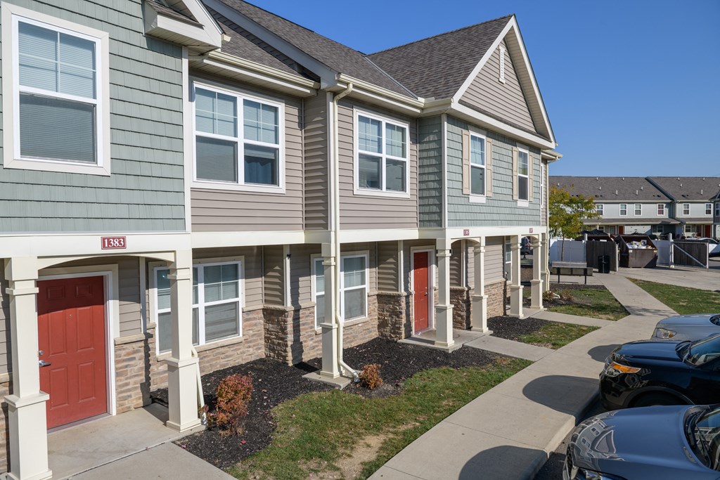 a row of town homes with red doors on a sidewalk